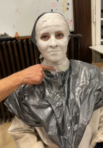 Moulage d'un visage avec des bandes platrées